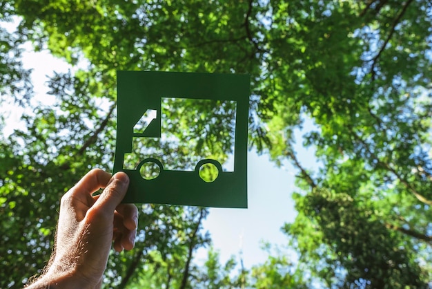 Mano che tiene il simbolo vivente verde ecologico