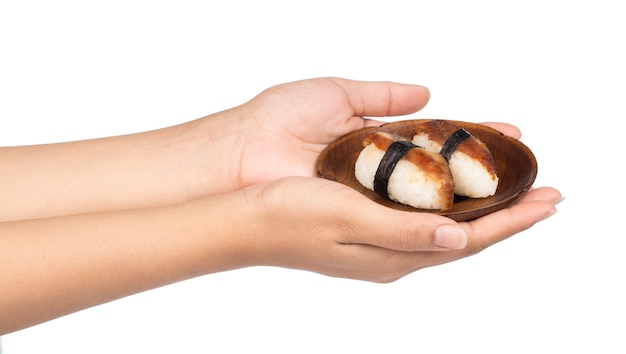 mano che tiene il sushi fresco su un piatto di legno isolato su sfondo bianco