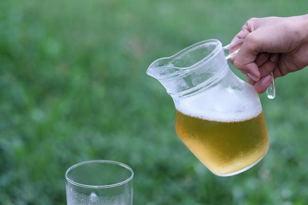 Mano che tiene la birra fredda per bere nel tempo di relax