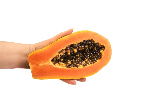 Mano che tiene la metà di frutta fresca di papaya matura con semi isolati su sfondo bianco