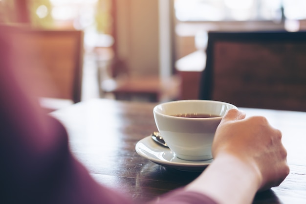 Mano che tiene la tazza di caffè