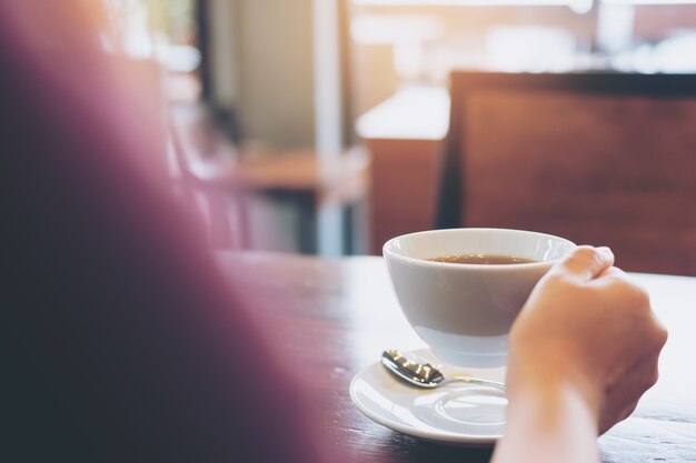 Mano che tiene la tazza di caffè