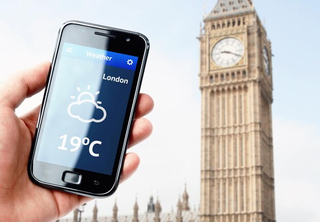 Mano che tiene lo smartphone con il tempo a Londra