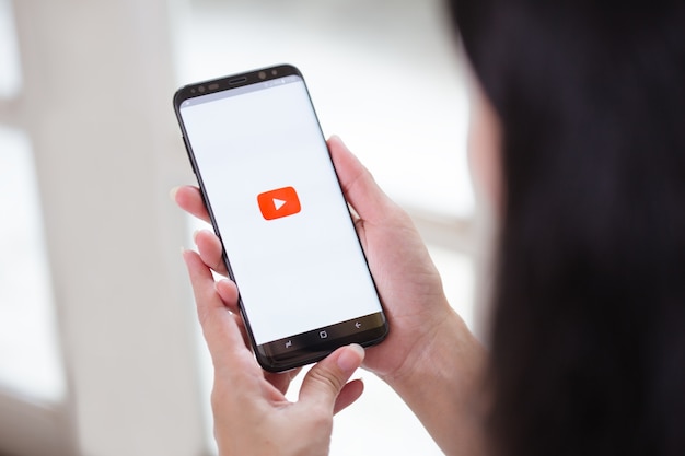 Mano che tiene smartphone con applicazione per Youtube