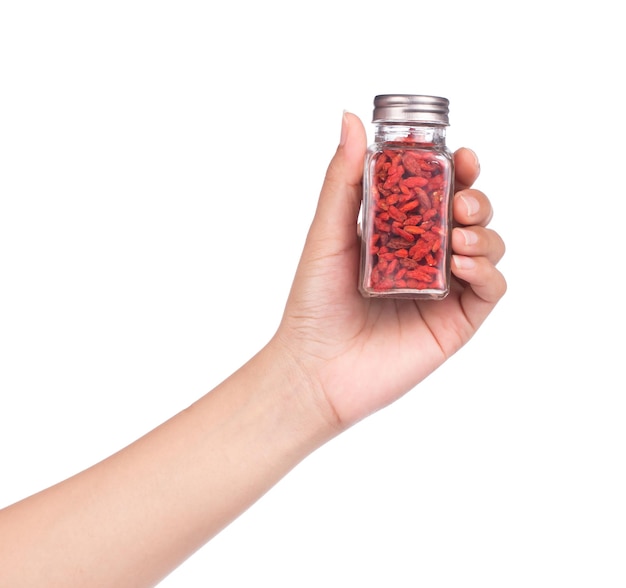 mano che tiene una bottiglia di Goji Wolfberries isolato su sfondo bianco