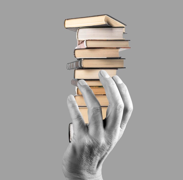 Mano che tiene una pila di libri su sfondo grigio Conoscenza sviluppo intellettuale saggezza letteratura importanza concetto Bianco e nero