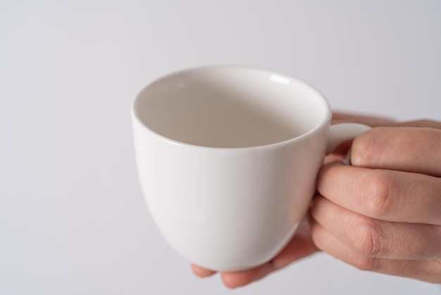 Mano che tiene una tazza di caffè su sfondo bianco isolare Asia donna mano con caffè bianco