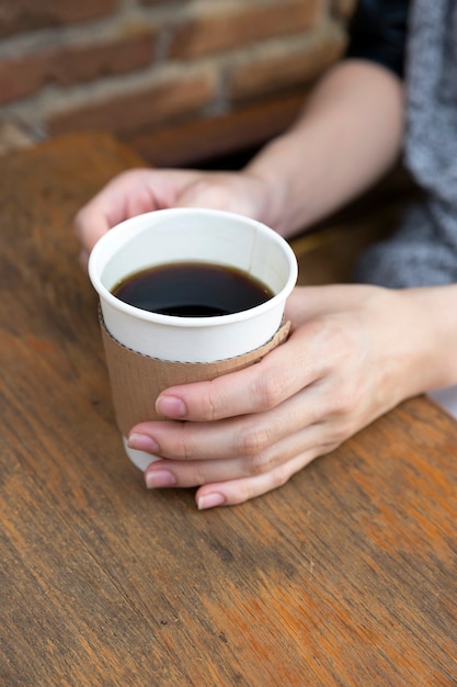 Mano che tiene una tazza di caffè