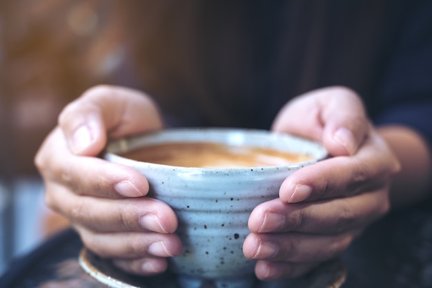 Mano che tiene una tazza di caffè