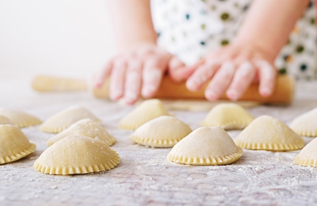 Mano con il mattarello e la farina che fanno gli gnocchi