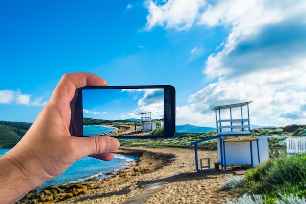 Mano con lo smartphone per scattare foto in una giornata di sole