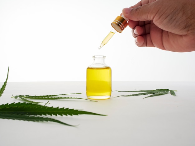 Mano con pipette e olio di estratto di cannabis.