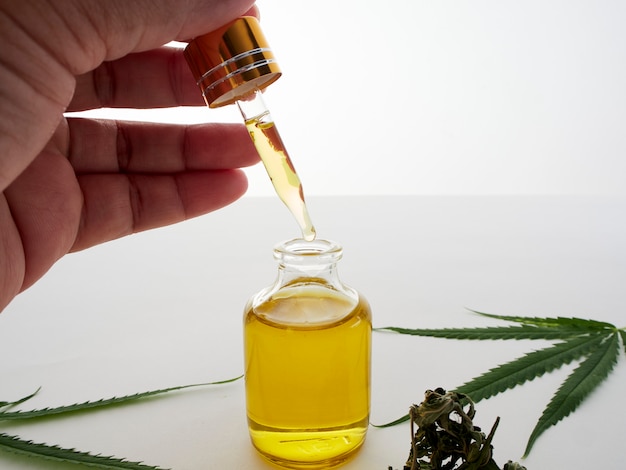 Mano con pipette e olio di estratto di cannabis.