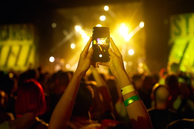 Mano con registrazione del telefono festival di musica dal vivo Persone che scattano fotografie con lo smartphone durante il concerto