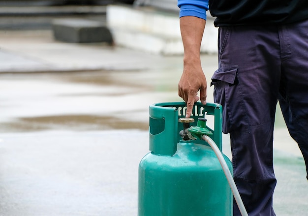 Mano d'uomo che indica la valvola aperta del gas GPL Dimostrazione della protezione antincendio causata dai piani dei vigili del fuoco di uso quotidiano