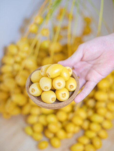 Mano da vicino che tiene frutta di datteri freschi nel concetto di spazio di copia