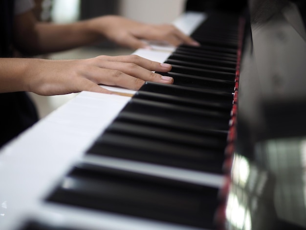 Mano del bambino sui tasti del pianoforte