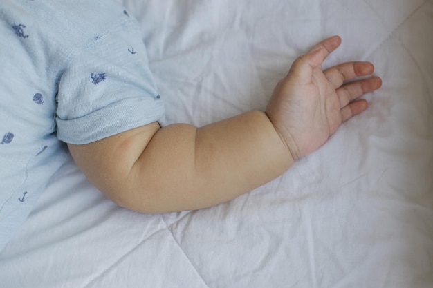 Mano del bambino sul letto a casa