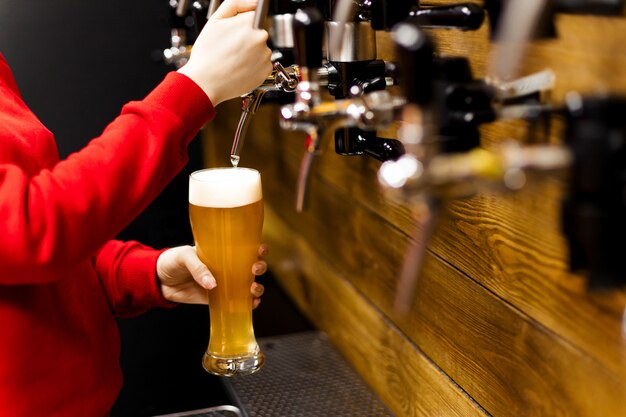 Mano del barista versando una birra grande birra alla spina