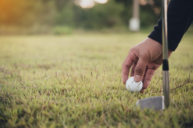 Mano del golfista asiatico che tiene golf sulla gente del prato della Tailandia gioca a golf