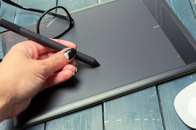 Mano del graphic designer che lavora con stilus e tablet