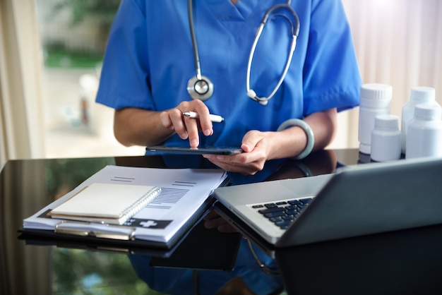 Mano del medico di medicina che lavora con l'interfaccia moderna del computer tablet digitale come concetto di rete medica