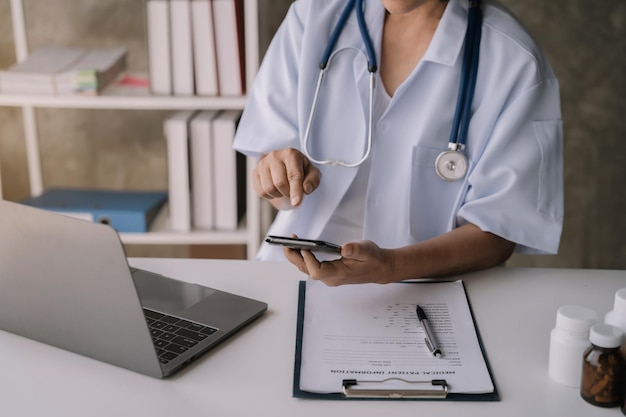 Mano del medico di medicina che lavora con lo smartphone digitale moderno e l'interfaccia del computer portatile come concetto di rete medica