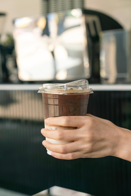 mano del primo piano che tiene la tazza di caffè del latte