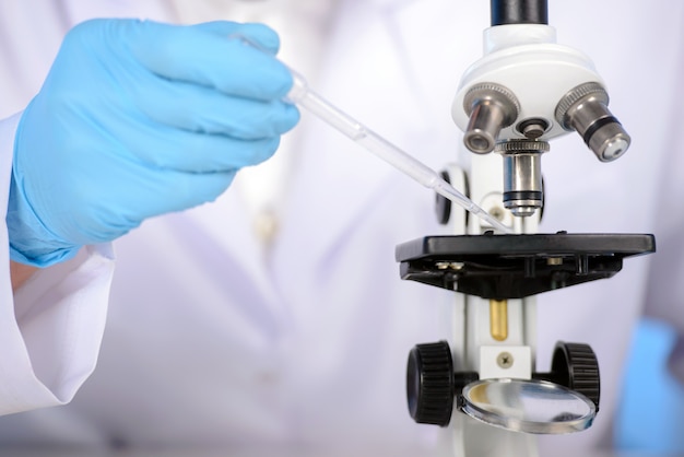 Mano dell'uomo che l'uso di un microscopio in un laboratorio.