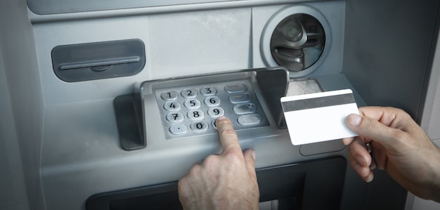 Mano dell'uomo con carta di credito. ATM. Prelevare denaro