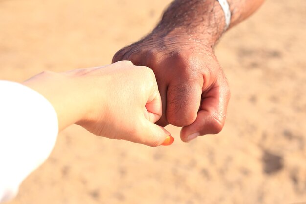 mano dell'uomo con la donna sulla sabbia