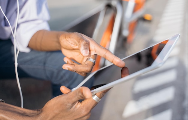 Mano dell'uomo con tavoletta digitale che punta il dito sullo schermo, messa a fuoco selettiva. I clienti che acquistano online