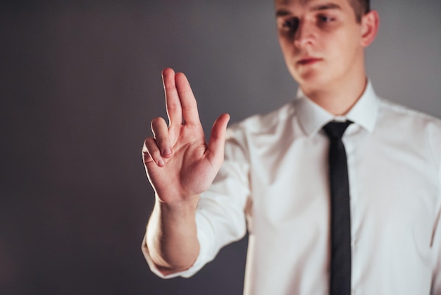 Mano dell'uomo d'affari che indica sullo spazio vuoto su fondo nero