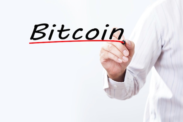 Mano dell'uomo d'affari che scrive Bitcoin con un pennarello rosso sul concetto di business della lavagna trasparente