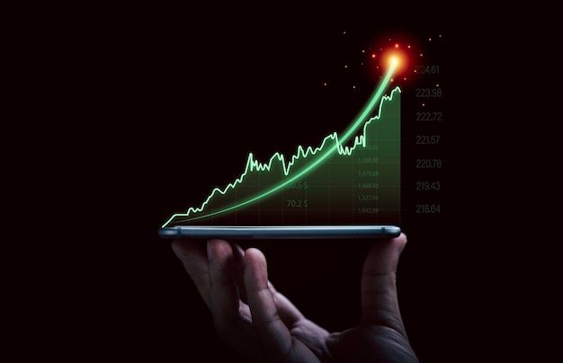 Mano dell'uomo d'affari che tiene smartphone con grafico e grafico di investimento virtuale in aumento per la tendenza dell'analisi del mercato azionario e il concetto tecnico di trader.