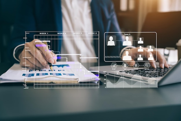 Mano dell'uomo d'affari Project manager che lavora e aggiorna le attività e il diagramma di Gantt che pianifica il diagramma virtuale con il laptop in ufficio