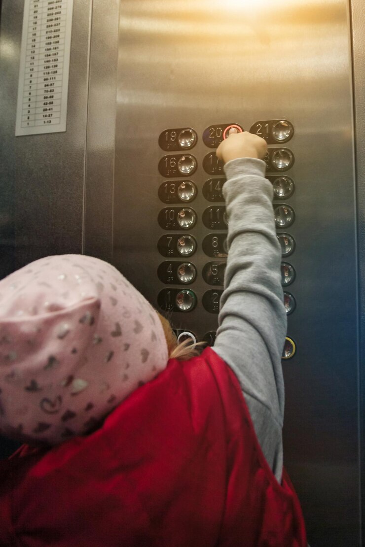 Mano della bambina premendo il pulsante dell'ascensore di chiamata numero venti