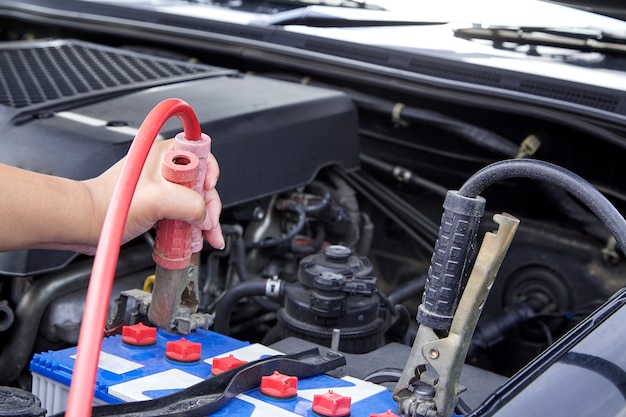 Mano della donna che controlla il motore della manutenzione dell&#39;automobile