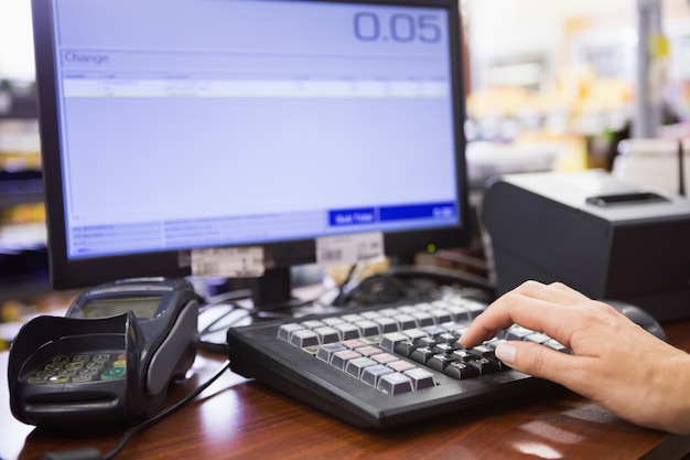 Mano della donna che per mezzo del computer