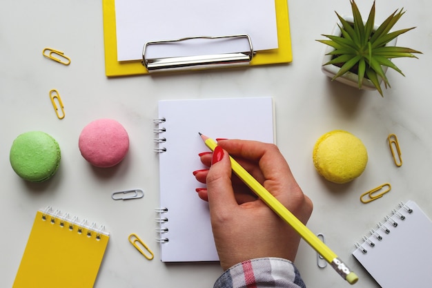 Mano della donna che scrive nel blocco note o nel taccuino