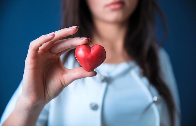 Mano della donna che tiene cuore rosso