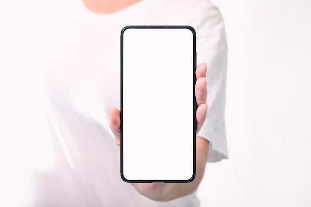 Mano della donna che tiene lo smartphone nero con lo schermo in bianco isolato su fondo bianco