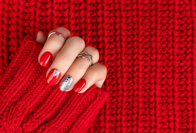 Mano della donna con il manicure rosso alla moda.