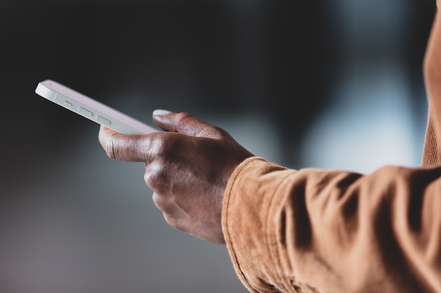 Mano della donna nera che tiene smartphone