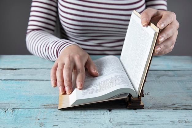 Mano della donna Sacra Bibbia sul tavolo