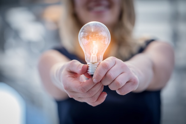 mano della donna tenere la lampadina