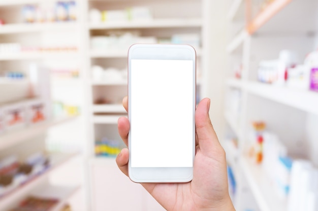 Mano della donna utilizzando smartphone mobile in farmacia