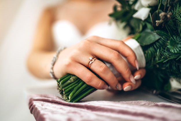 mano della sposa con anello e fiori