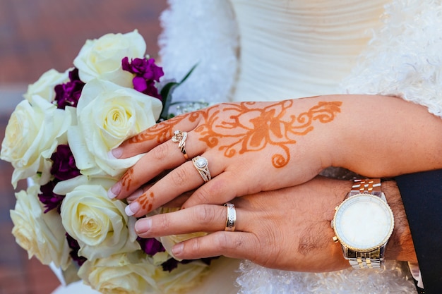 Mano della sposa con tatuaggi all&#39;henné e gioielli, matrimonio