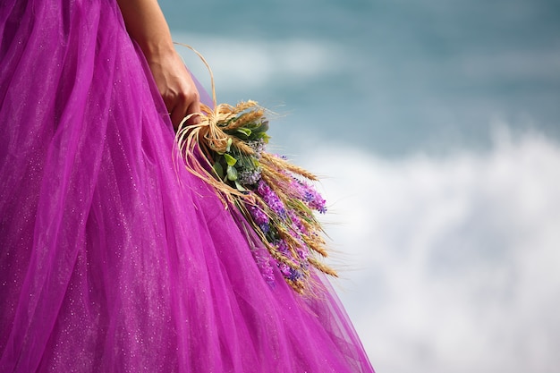 Mano della sposa con un bouquet da sposa